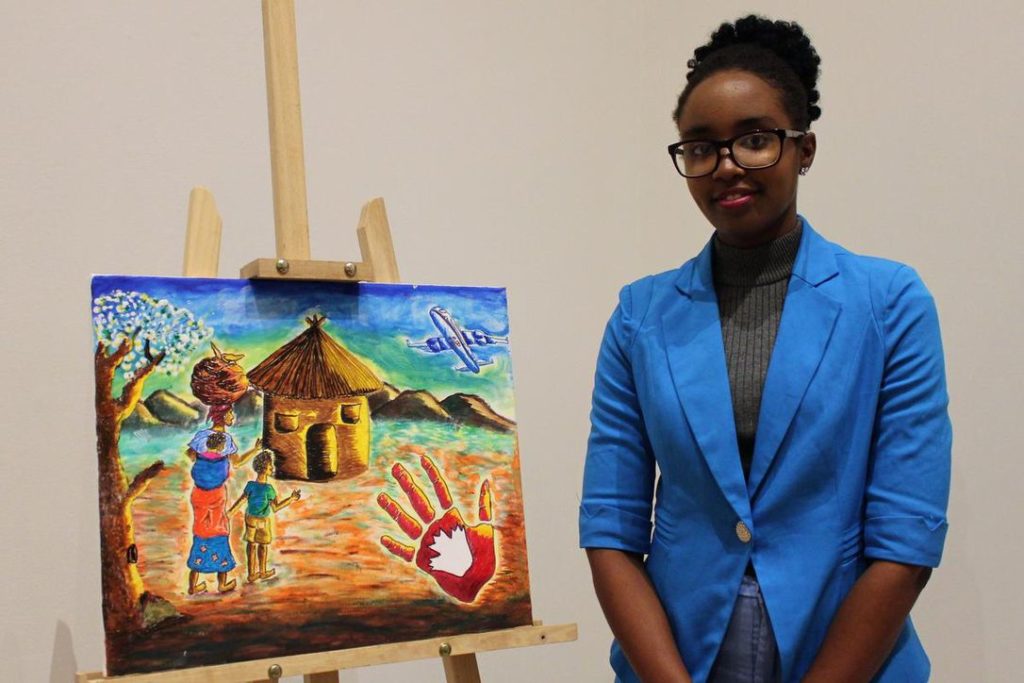 Chadia Kayinamura, 23, stands with a painting inspired by her refugee experience. Born in the Congo, she and her family spent 17 years as refugees in Uganda before immigrating to Canada last year.  (TARYN GRANT / STARMETRO HALIFAX)