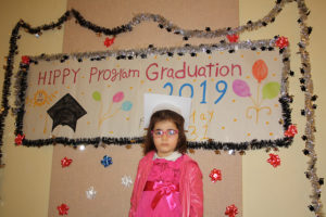Girl in front of graduation sign