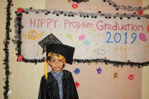 Boy in front of graduation sign