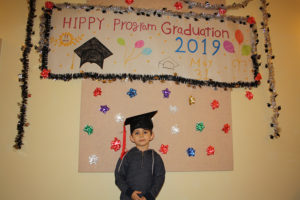 Little boy in front of graduation sign