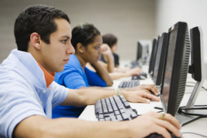 a multiethnic group of students working on computers in a computer lab