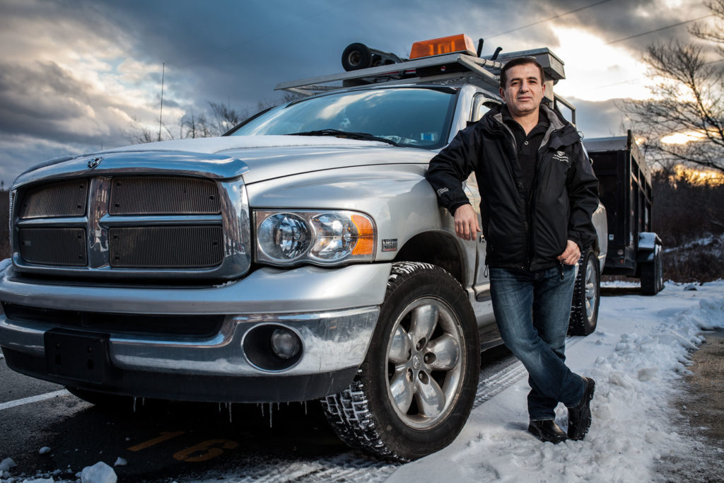Immigrant entrepreneur standing next to his truck