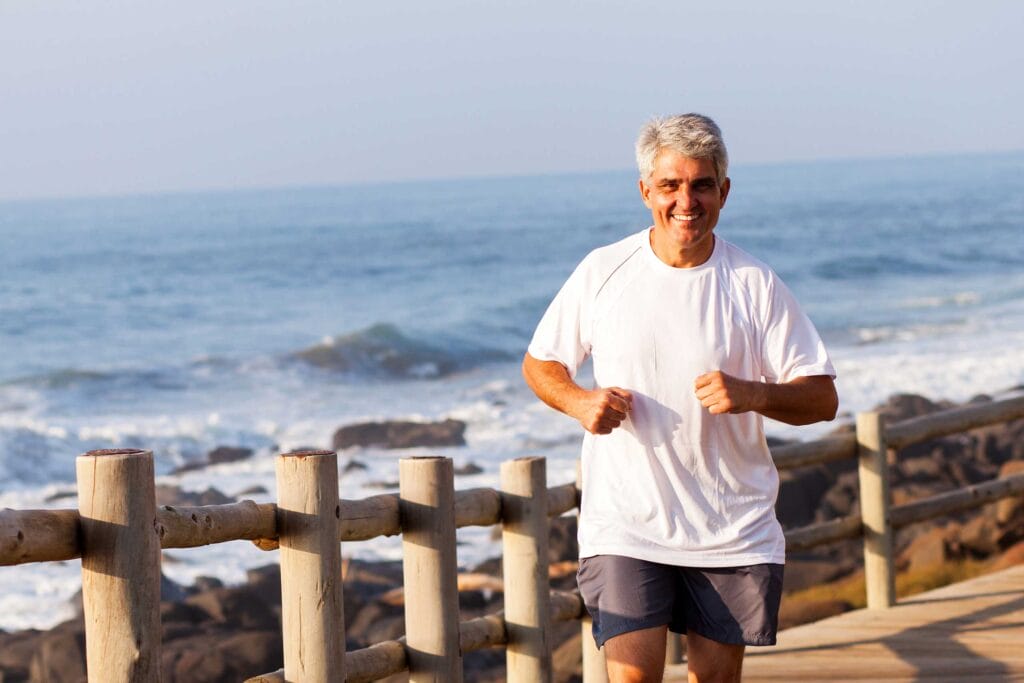 A senior immigrant jogging along the ocean