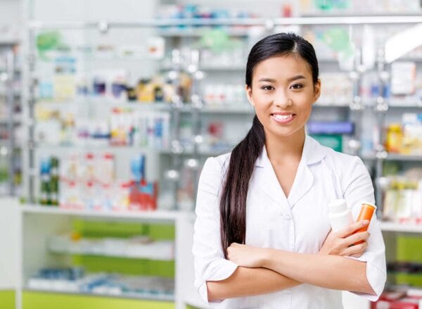 An internationally educated female pharmacist holding medicine bottles