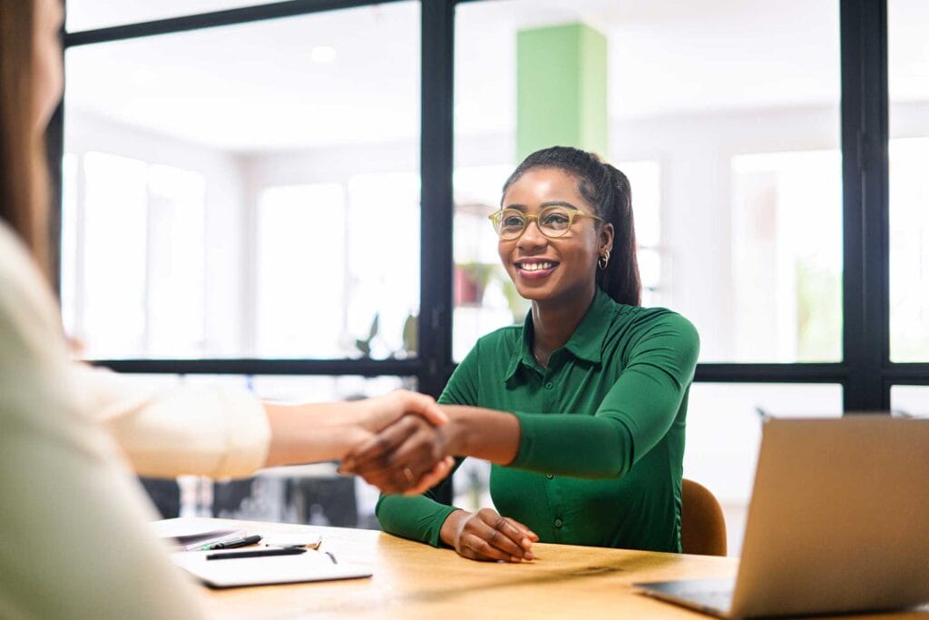 An immigrant job seeker shaking hands with employer during interview