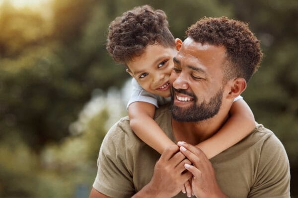 A newcomer father carrying his child on his back having fun