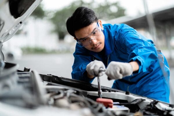 An internationally trained mechanic fixing a car