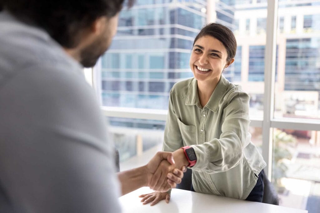 A skilled foreign worker shaking hands with employer during a job interview