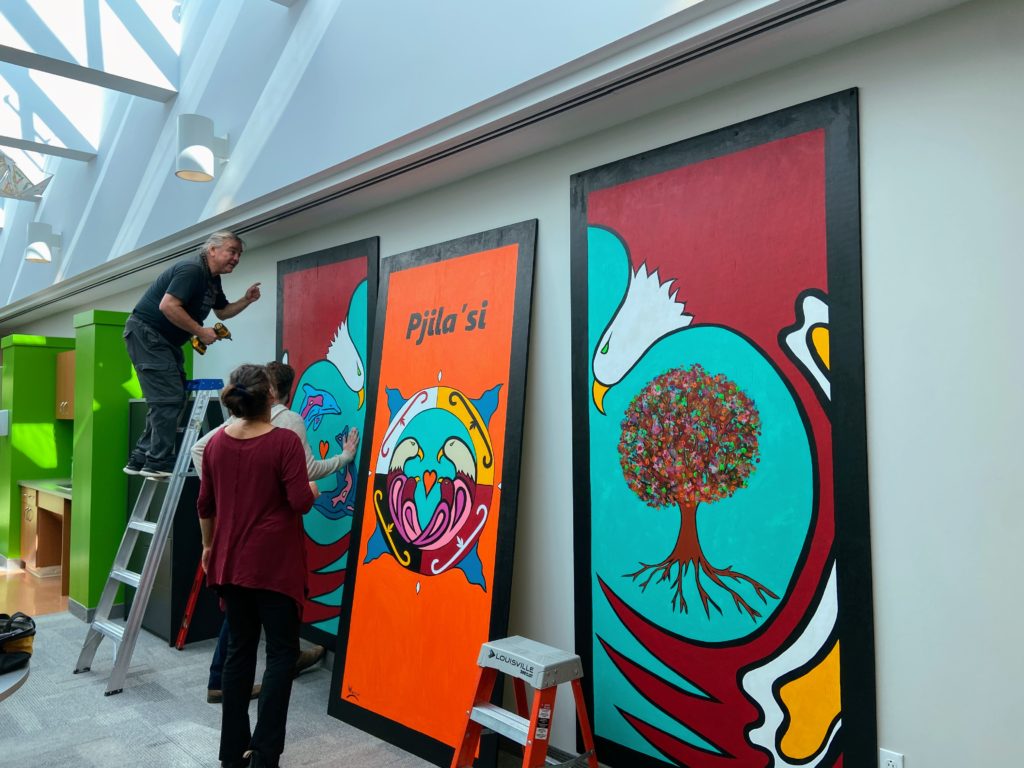 Lorne Julien installing murals at ISANS