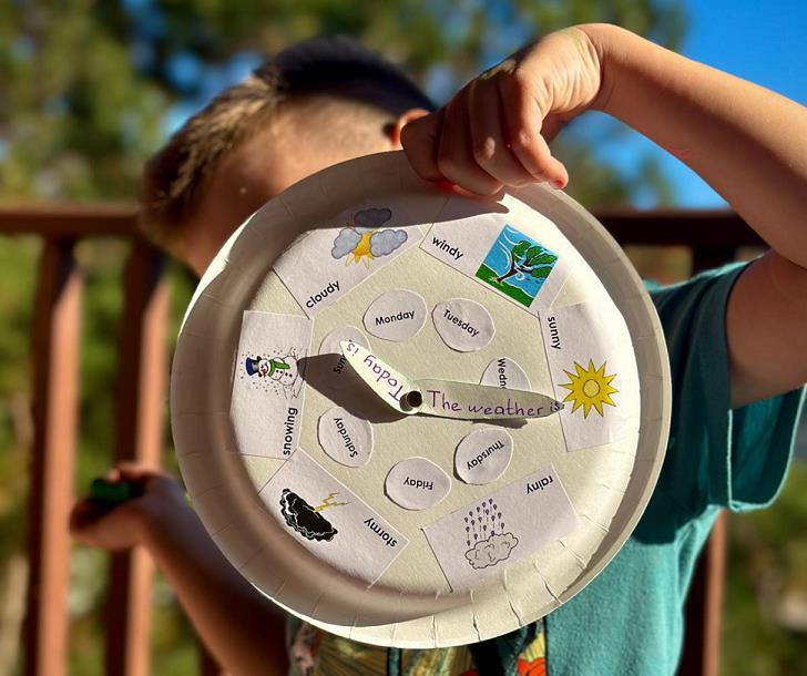 A child holding a paper clock