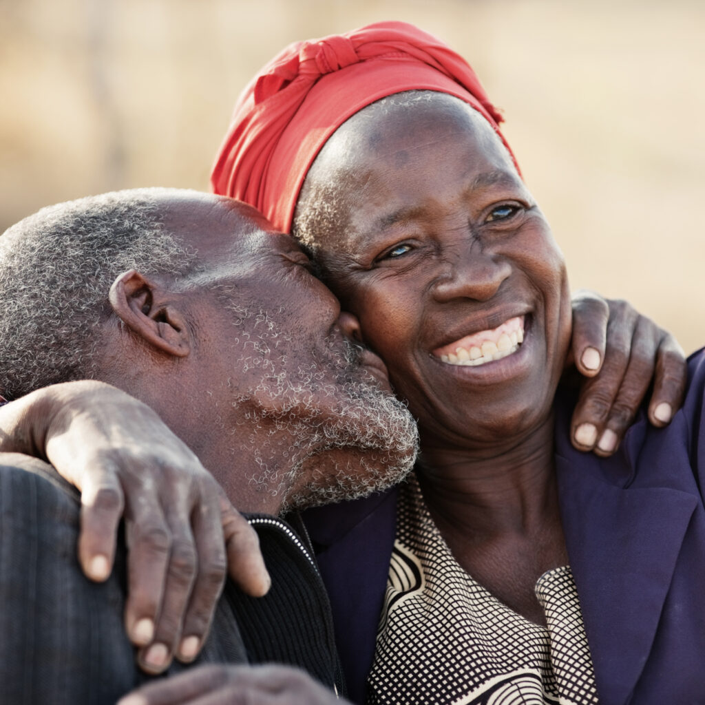African couple in their eighties and seventies, hugging and kissing
