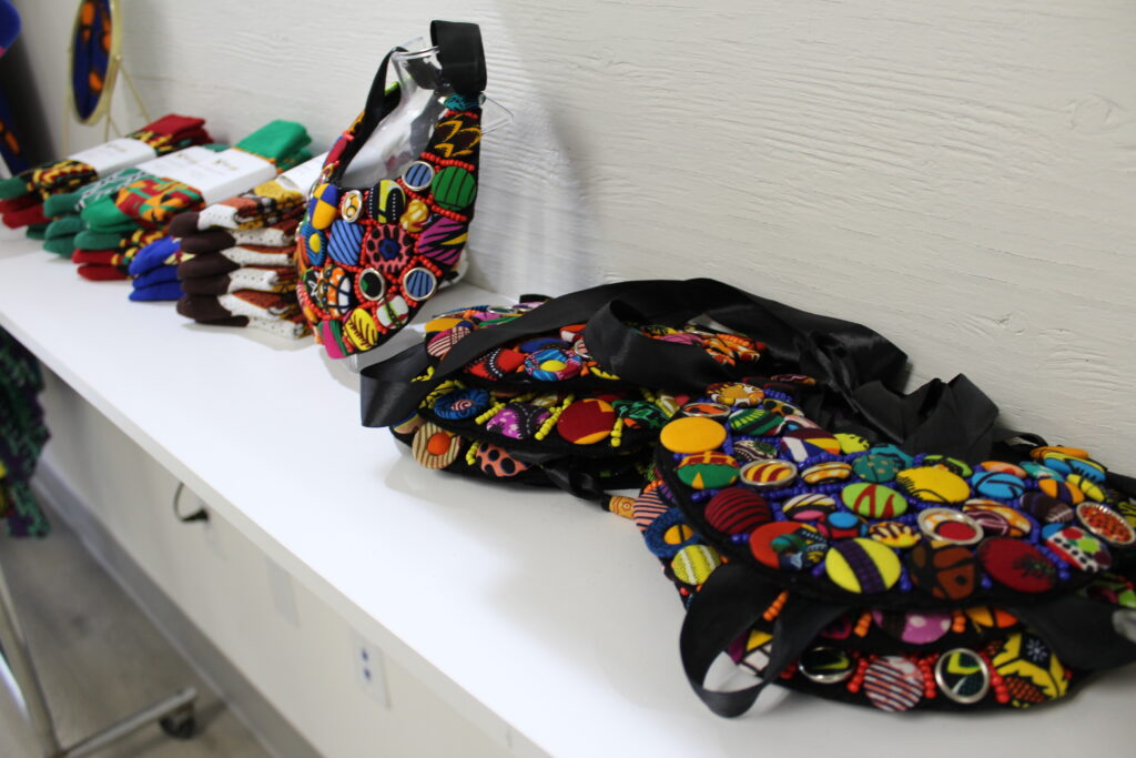 a close-up of medium size colorful bags, as well as socks, sit on a white shelf