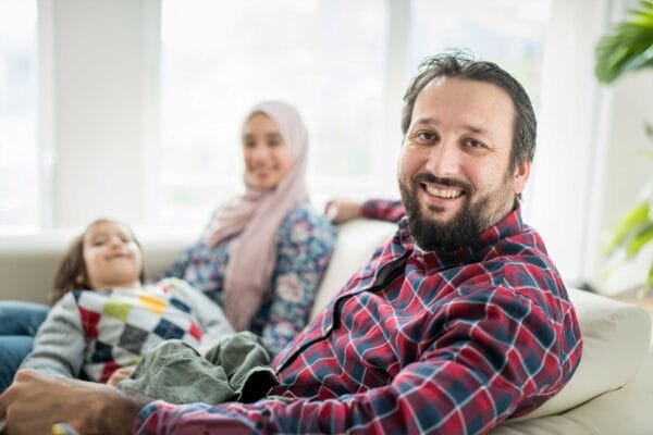 A refugee family smiling inside their home