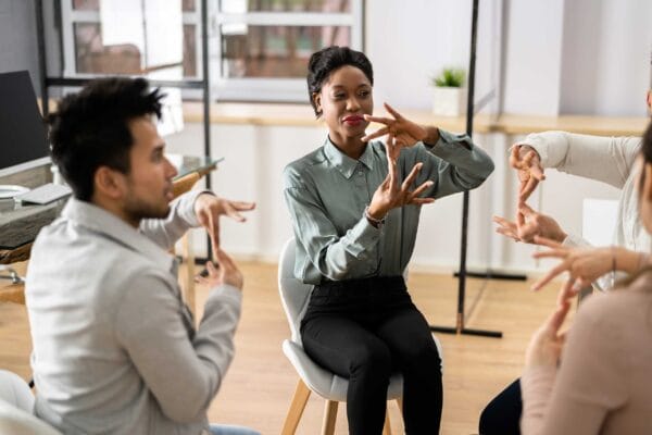 A diverse group using sign language to each other