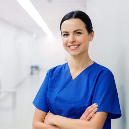A happy internationally educated female nurse standing in a hospital