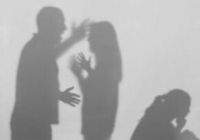 Silhouettes of quarreling parents and little child on white background. Domestic violence concept