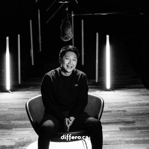 Black and White photo of the behind the scene for Chamber of Commerce Business Award shoot. Will is sitting in a chair in front of the camera