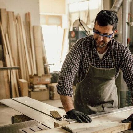 An immigrant carpenter working with wood