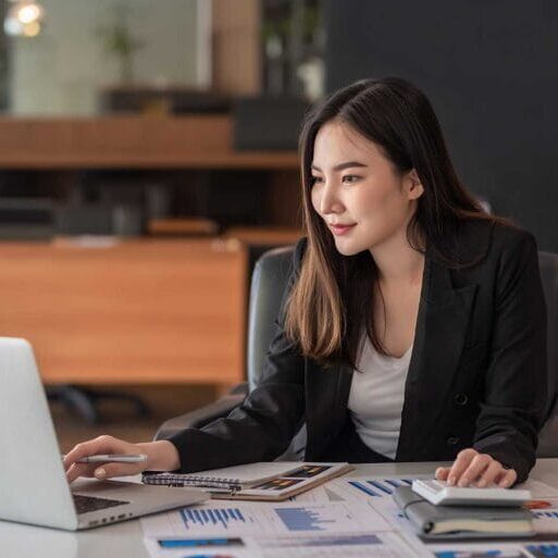 An employment counselling specialist using a laptop and a calculator