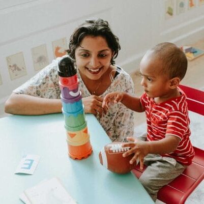An immigrant woman and child playing with toys