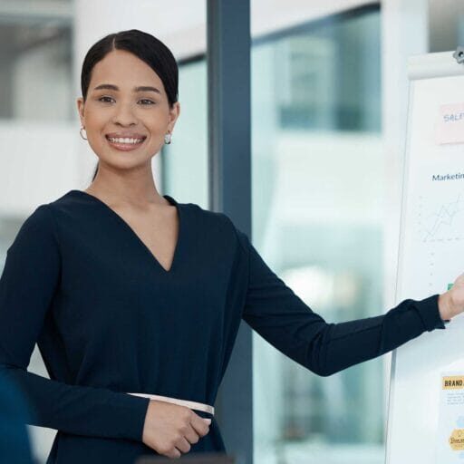 A female immigrant professional presenting her report pointing at graphics on white board