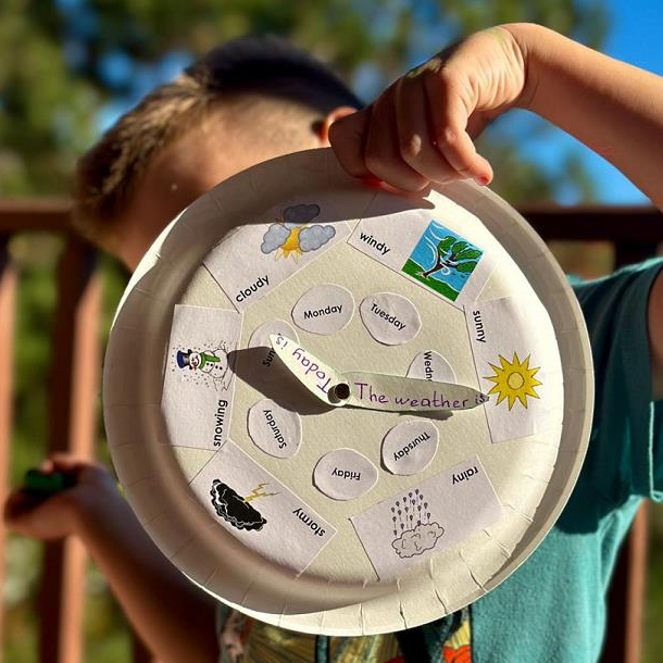 A child holding a paper clock