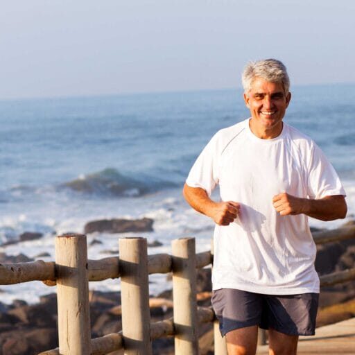 A senior immigrant jogging along the ocean