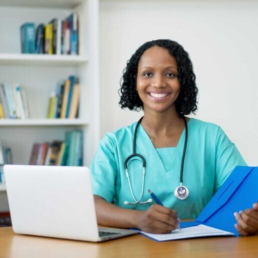 An internationally trained nurse smiling and writing a report
