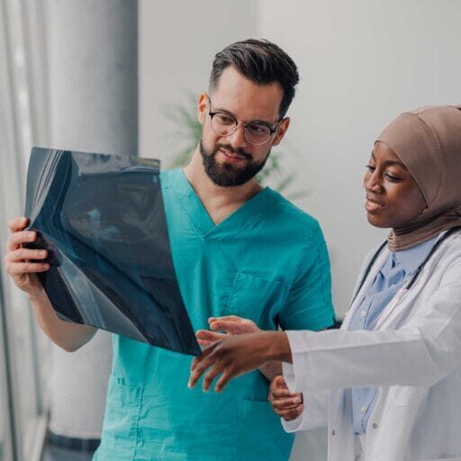 Two internationally trained medical professionals looking at xray
