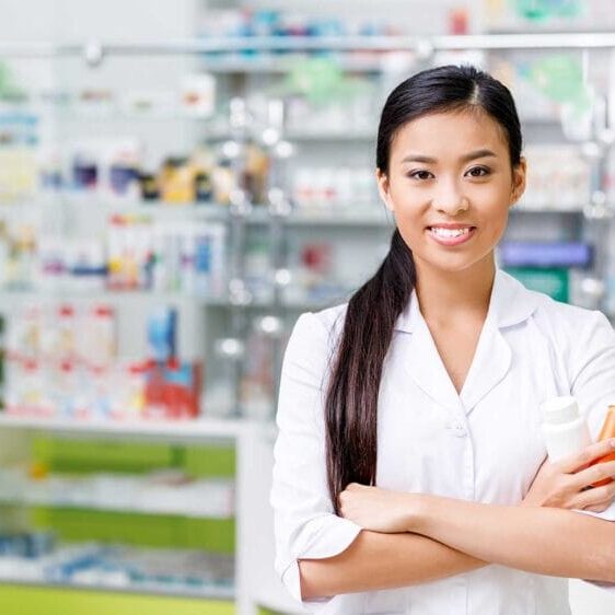 An internationally educated female pharmacist holding medicine bottles