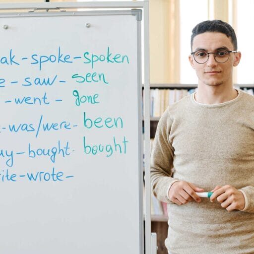 An immigrant youth standing next to a white board with English words