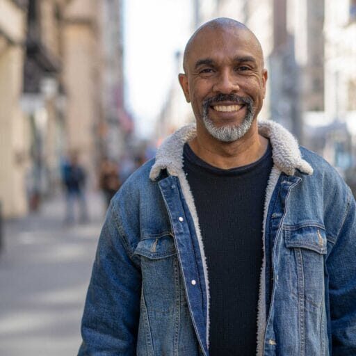 A newly arrived male refugee smiling in the street