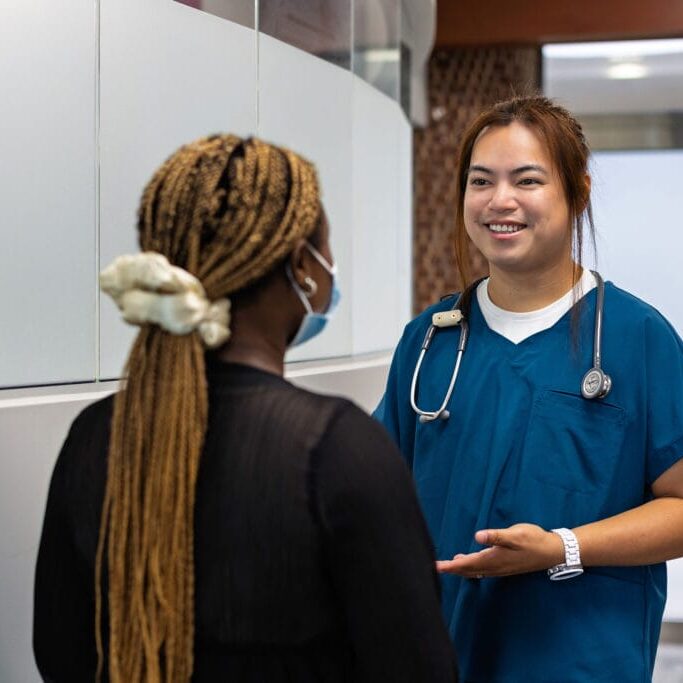 A nurse smiling and interacting with a patient
