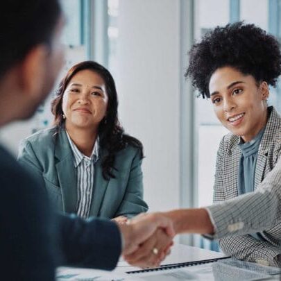 Two female employers smiling at a candidate during a job interview