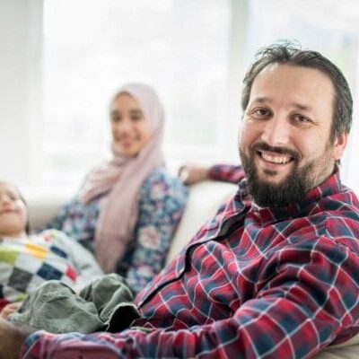 A refugee family smiling inside their home