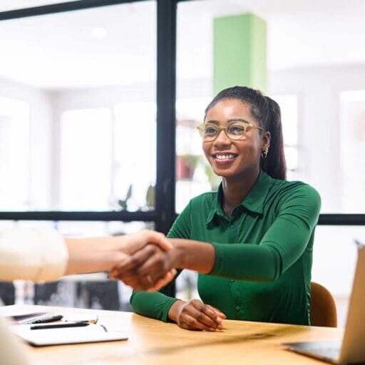 An immigrant job seeker shaking hands with employer during interview