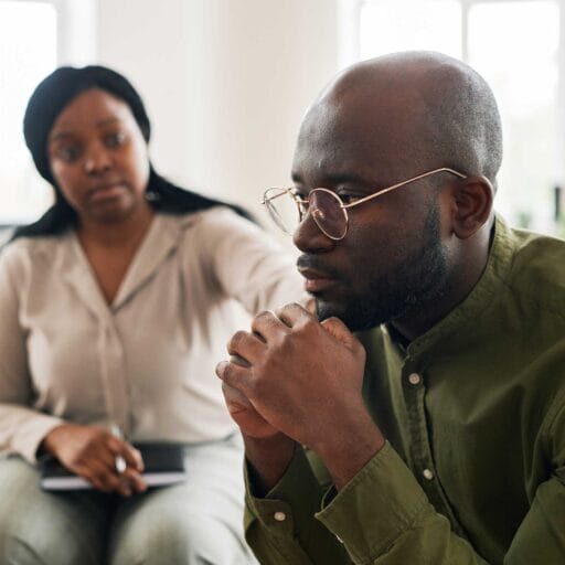 A troubled male newcomer receiving help from a specialized settlement counsellor