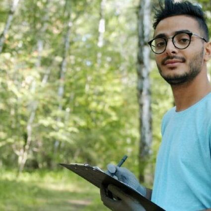 A male youth working with other youth in the forest